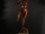a bronze statue of an angel holding a bird on top of a pedestal
