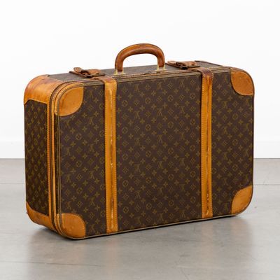 une valise marron et beige posée par terre