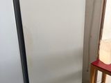 two white refrigerators next to each other in a room