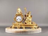 une horloge en or posée sur un socle en marbre
