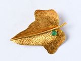 une broche en feuille d'or sertie d'une pierre verte