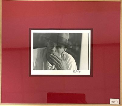 une photo encadrée représentant un homme portant un chapeau et tenant une cigarette