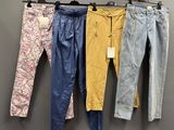 trois paires de jeans suspendues à un portant dans un magasin