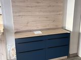 an image of a room with a wooden wall and a blue dresser