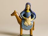 figurine représentant une femme assise sur un chameau avec un bébé