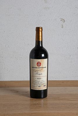 a bottle of red wine sitting on a wooden table