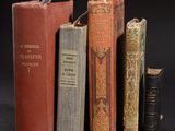 several old books are stacked on top of each other on a black surface
