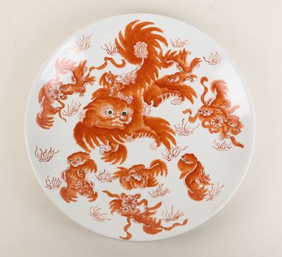 une assiette orange et blanche sur laquelle est représenté un groupe d'animaux