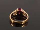 a close up of a gold ring with a ruby stone