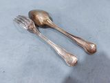 two silver spoons and a fork on a table