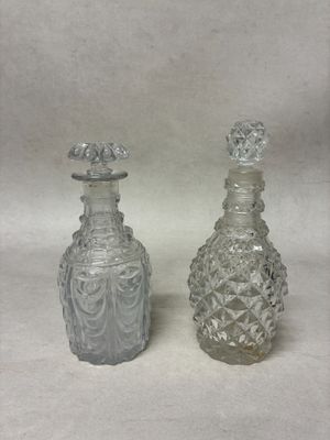 paire de bouteilles anciennes en verre taillé, munies de bouchons sur le dessus
