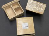 Trois petites boîtes en bois sont posées sur une table