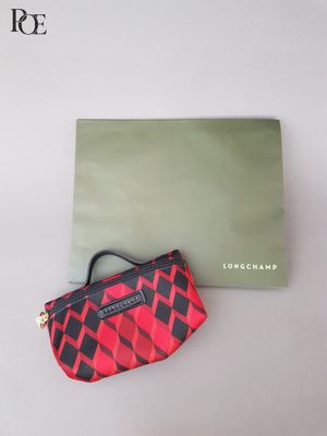 le sac à main est posé à côté d'une boîte verte ornée d'un motif rouge et noir