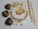 Plusieurs bijoux en or sont exposés sur un fond blanc