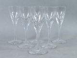 six clear wine glasses sitting on top of a white table