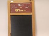 un tableau noir accroché au mur sur lequel est écrit « Café de Flore »
