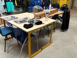 une table sur laquelle sont posés de nombreux vêtements, dans une pièce