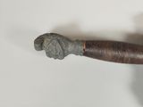 a metal object with a handle on a white surface