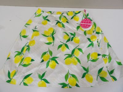 a close up of a white skirt with yellow lemons on it