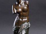 a bronze statue of a woman holding a vase