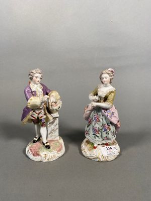 two figurines of a man and a woman with a child
