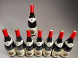 six bottles of wine are lined up in a row on a table