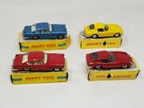 four dinky toys cars are sitting on top of a box