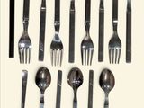 a lot of forks and spoons that are on the table
