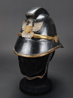 un vieux casque noir surmonté d'un aigle doré