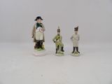 three figurines of men dressed in military uniforms