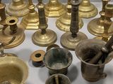 many different types of brass candles on the table