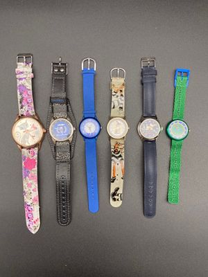 Plusieurs montres différentes sont alignées sur une table