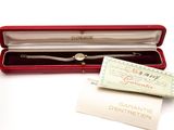 a silver bracelet in a red box with a white tag
