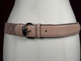 the belt is made of leather and has a metal buckle on it