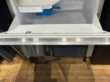 a small open refrigerator with a blue handle on it