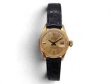une image d'une montre-bracelet en or avec un bracelet en cuir noir