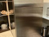 a stainless steel refrigerator in the corner of a kitchen