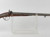 un vieux fusil au canon en bois, posé sur un socle transparent