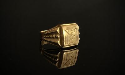 gros plan d'une bague en or sur une surface noire