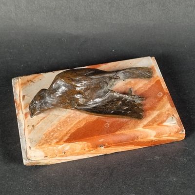 sculpture représentant un oiseau sur un bloc de marbre posé sur une surface noire