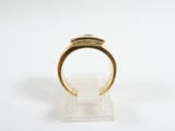 a close up of a gold ring on a white surface