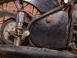 a close up view of an old motorcycle parked in front of a brick wall