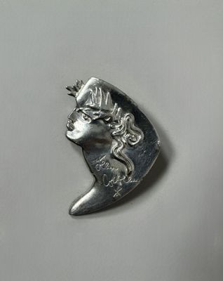 a close up of a silver coin with a woman ' s face on it