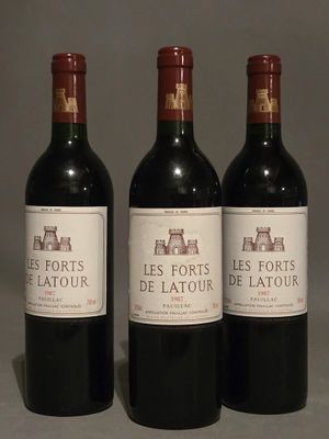 three bottles of red wine are lined up on a table