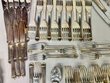 a lot of silver spoons and forks on the table