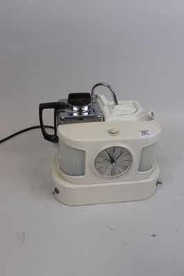 a white clock that is sitting on a white table