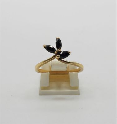 un gros plan d'une bague en or sertie de pierres noires