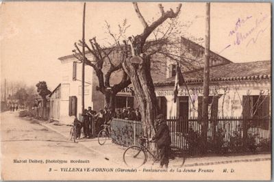 une vieille photo d'un homme qui roule à vélo dans la rue