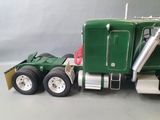 a green toy truck with a large trailer on it