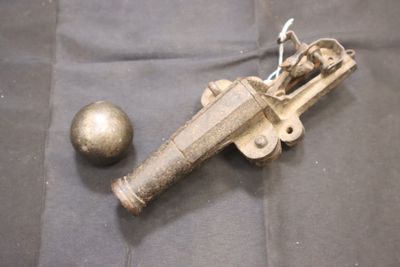 un pistolet jouet et une balle posés sur un tissu noir